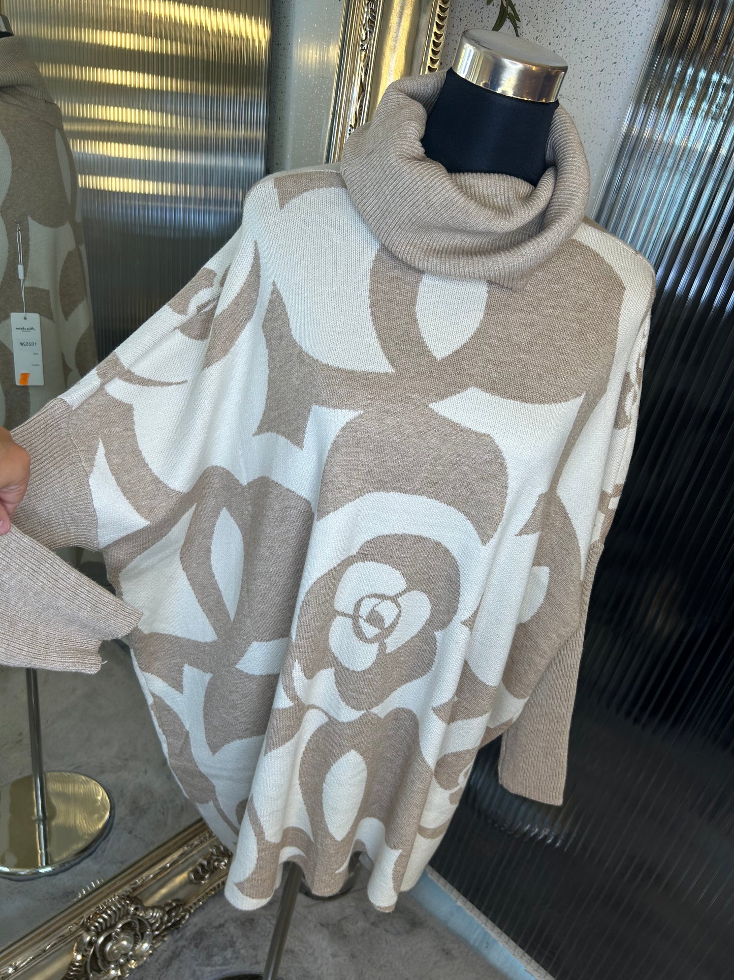 A beige and white floral printed roll neck oversized jumper.