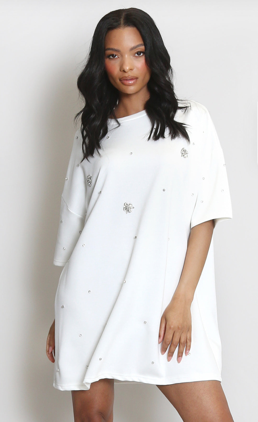 Woman wearing a white dress t-shirt with crystal patterns