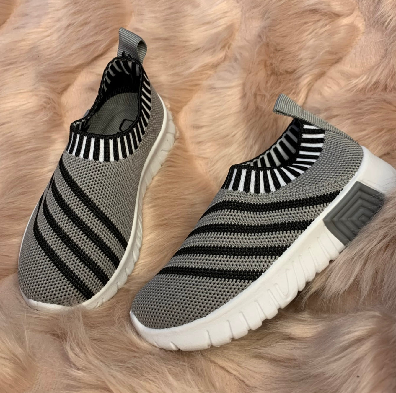 A pair of grey & black stripe kids' slip-on athletic shoes