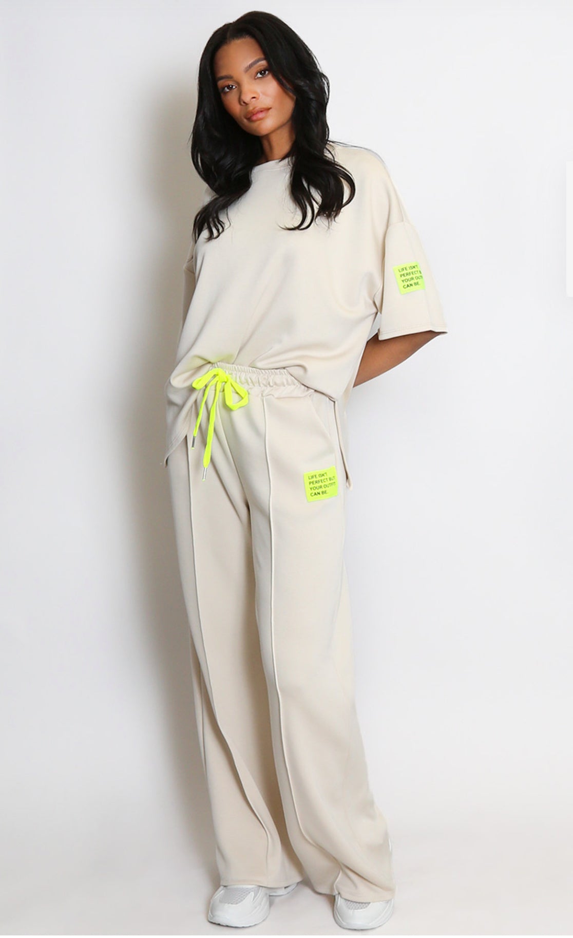 Woman wearing a beige outfit with neon accents