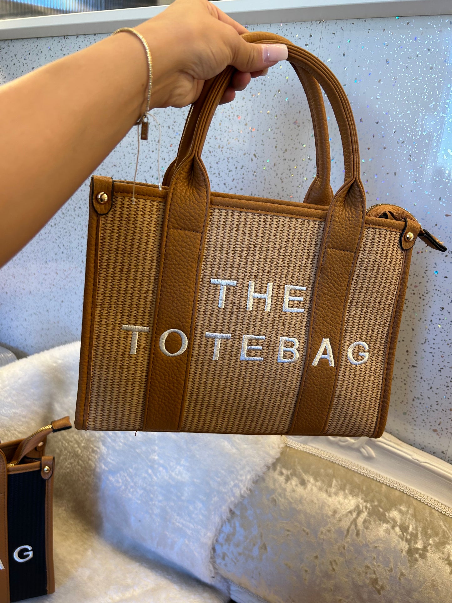 Brown and beige woven tote bag with 'THE TOTE BAG' text