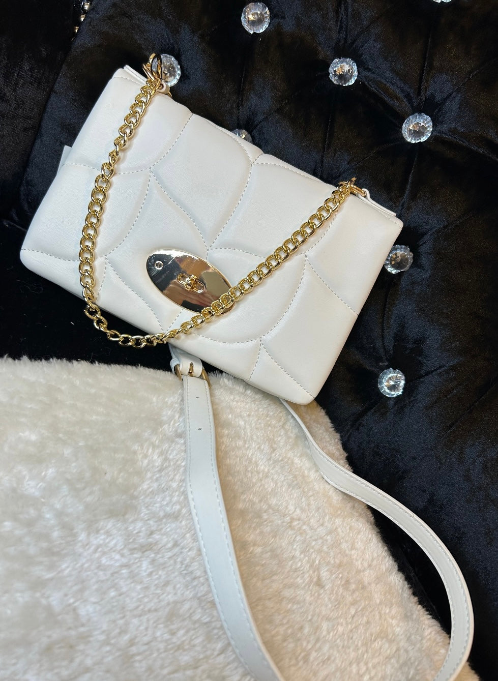 White quilted handbag with a gold chain strap