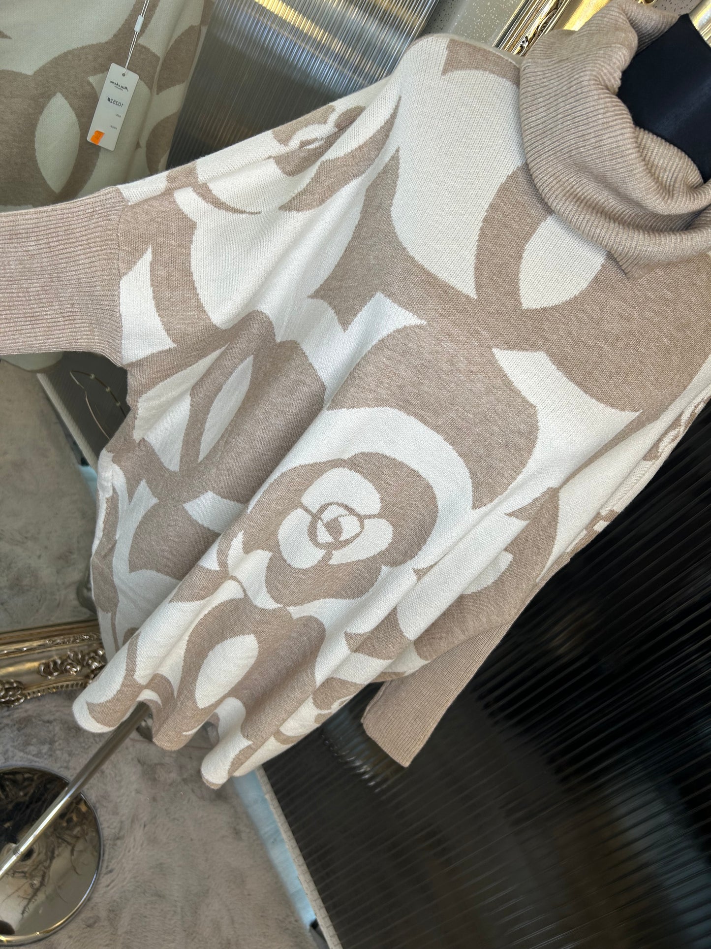 A beige and white floral printed roll neck oversized jumper.