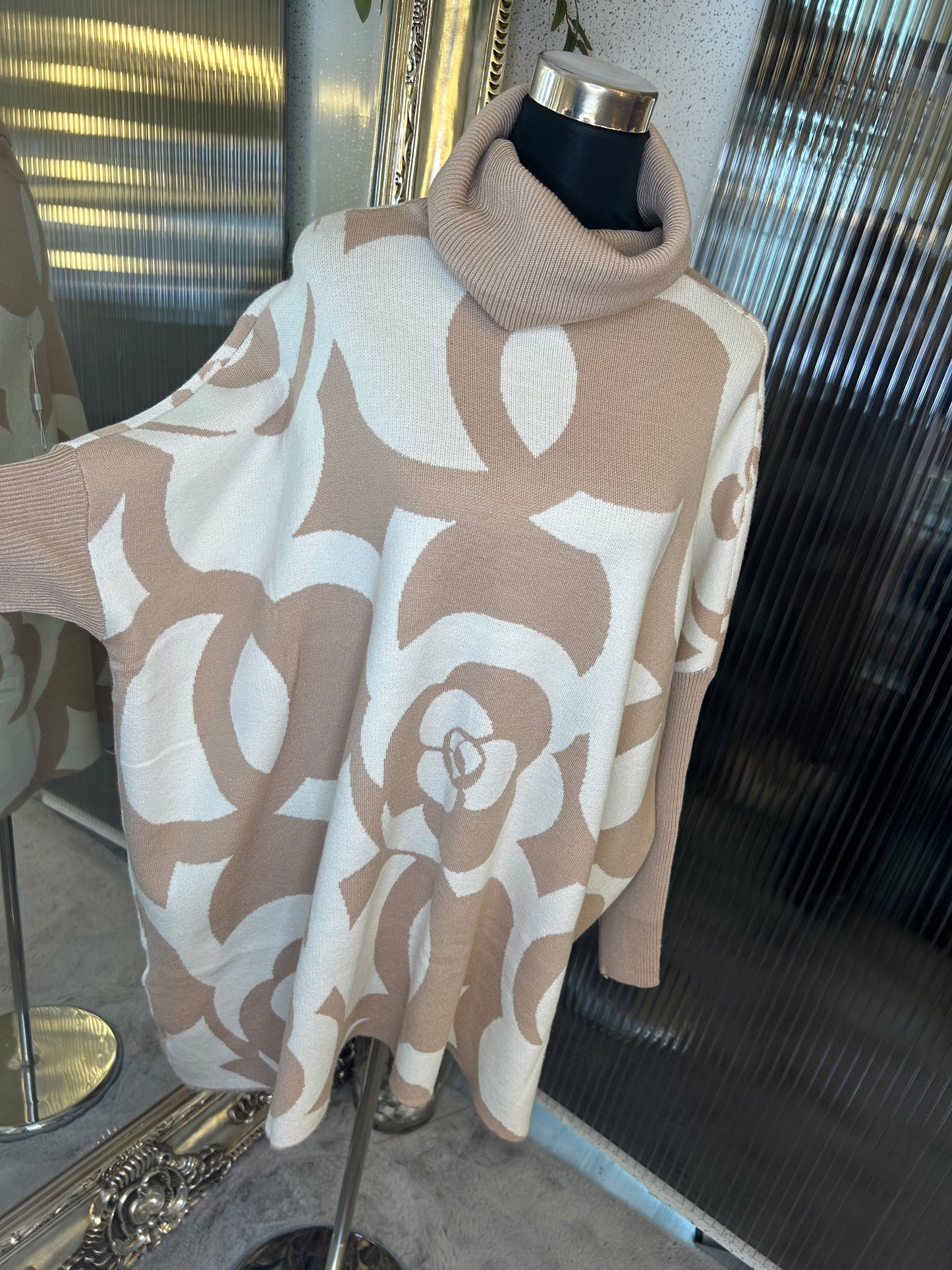 A beige and white floral printed roll neck oversized jumper.