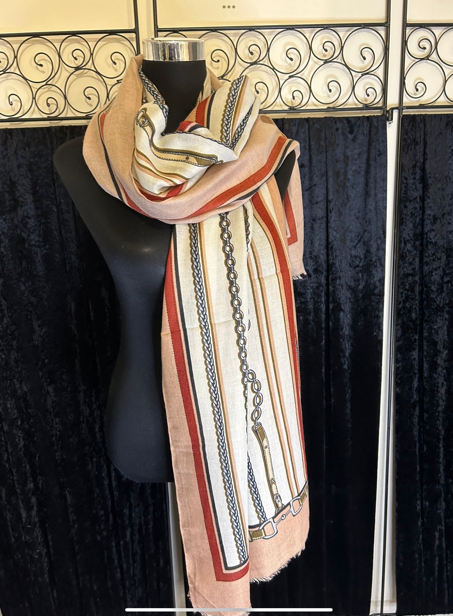 Colourful chain print scarf with stripes in cream, red, and peach tones, displayed on a mannequin.