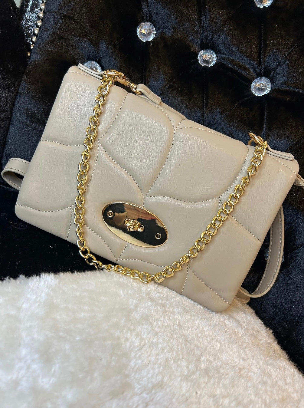 Beige quilted handbag with a gold chain strap