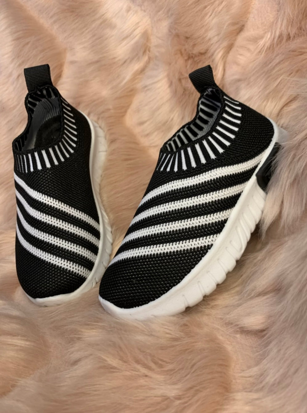 A pair of black & white stripe kids' slip-on athletic shoes