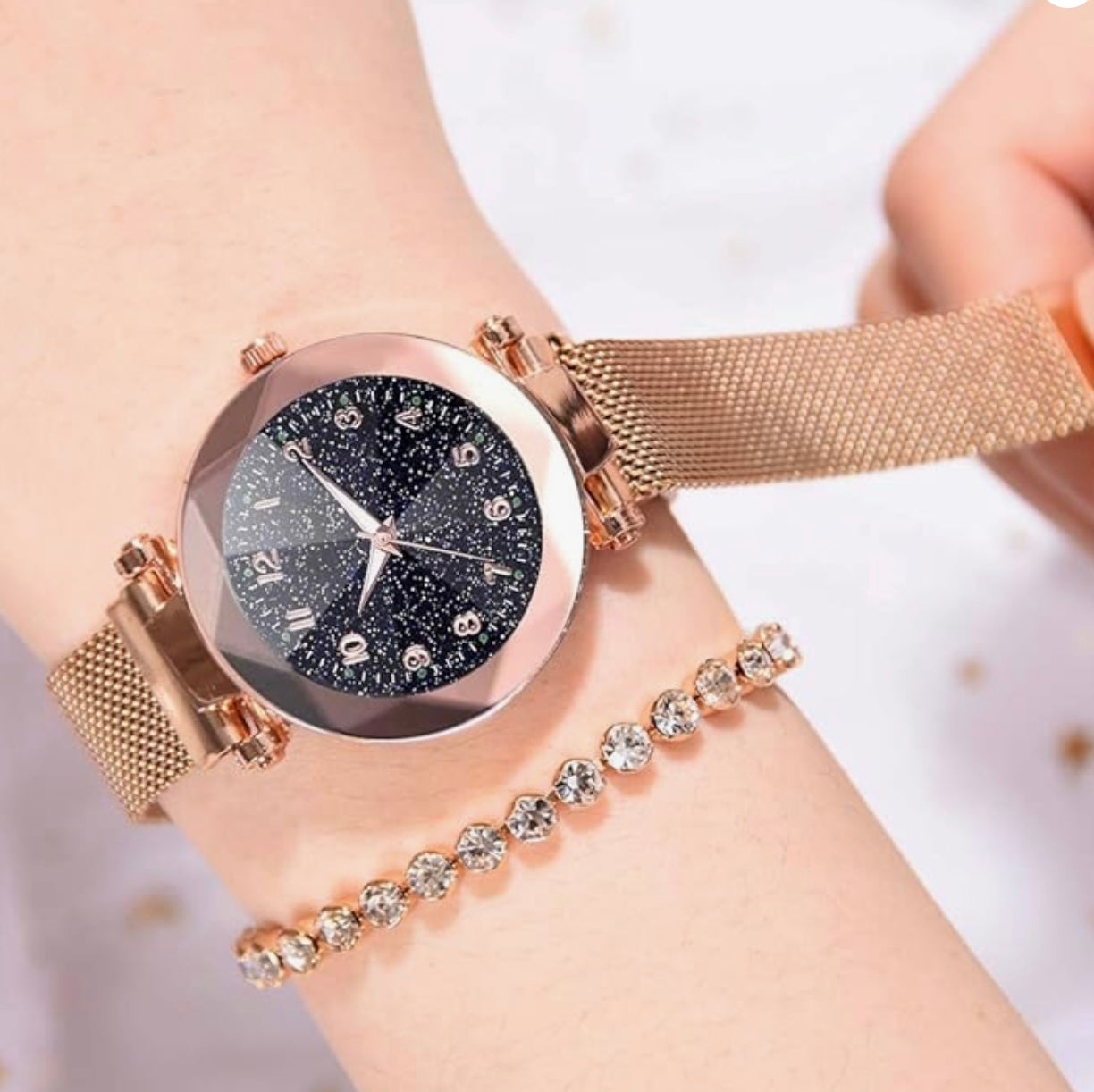 A rose gold Wristwatch with a glitter face with a magnetic closure strap