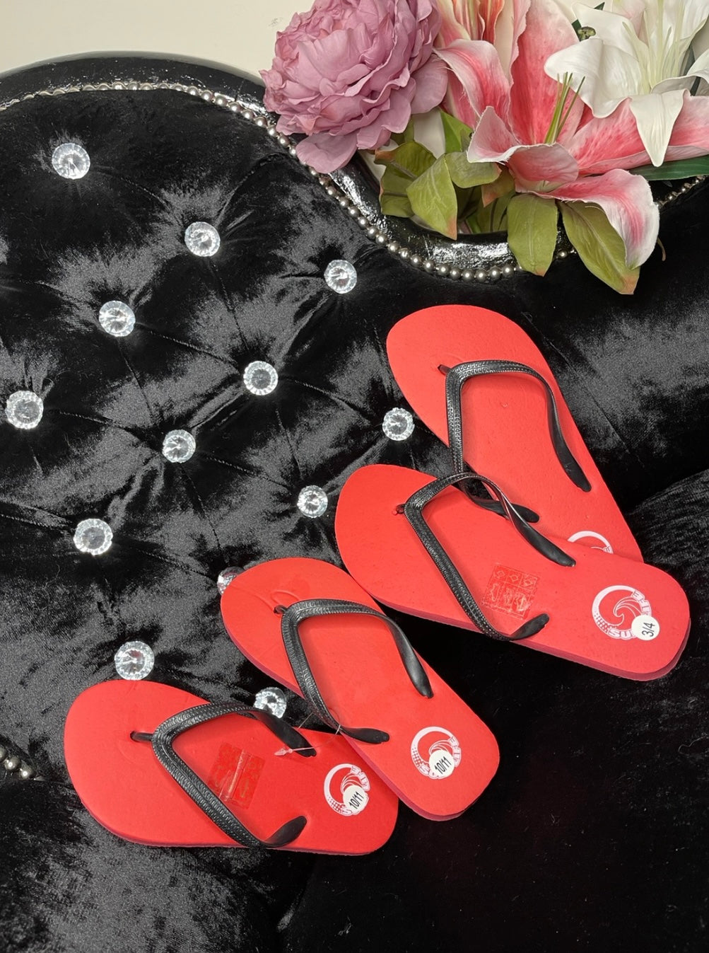 Red sole flip flop toe posts in a rubber material with black straps