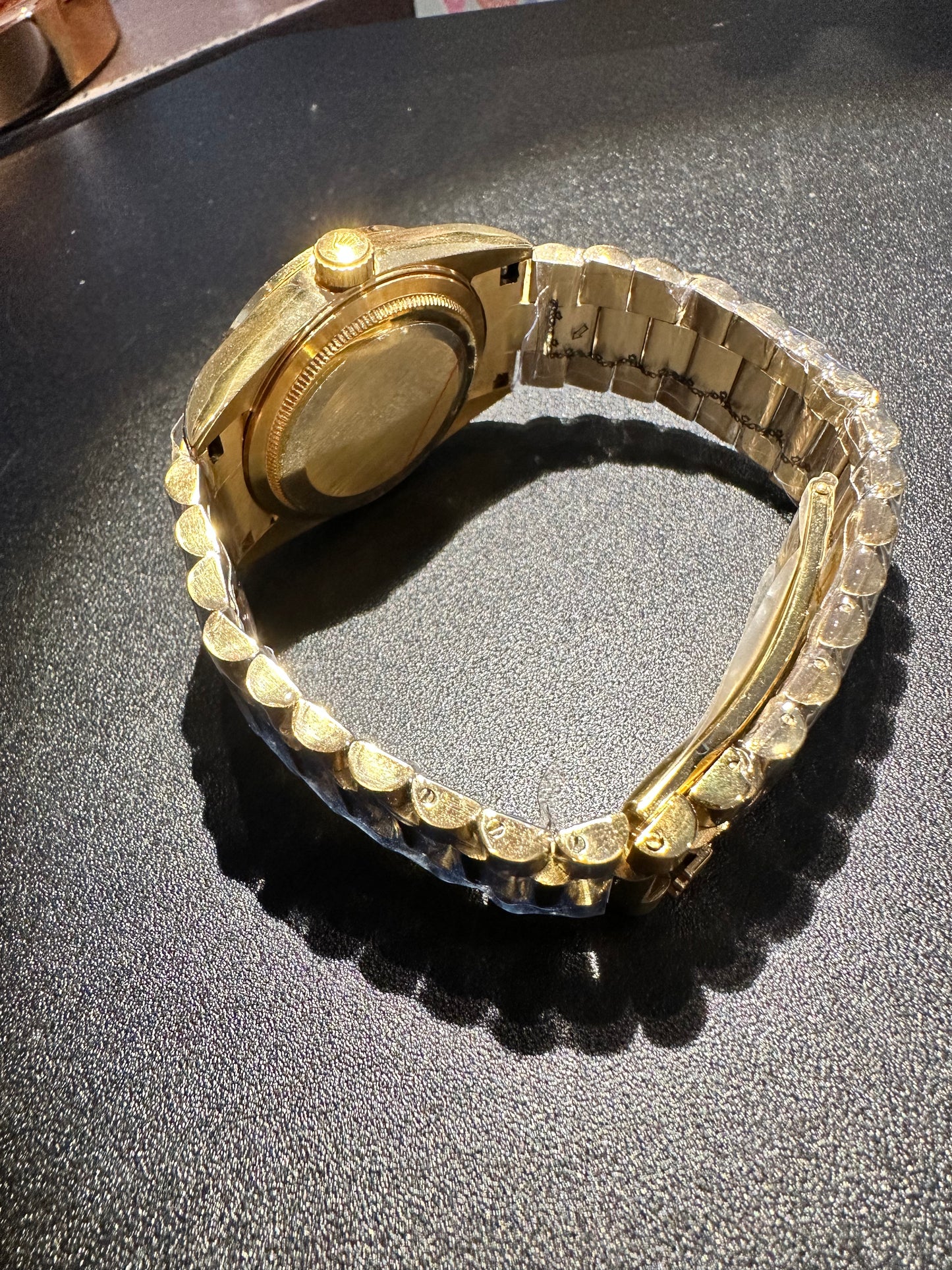 A gold-coloured watch with an orange dial and bling crystal rhinestones.