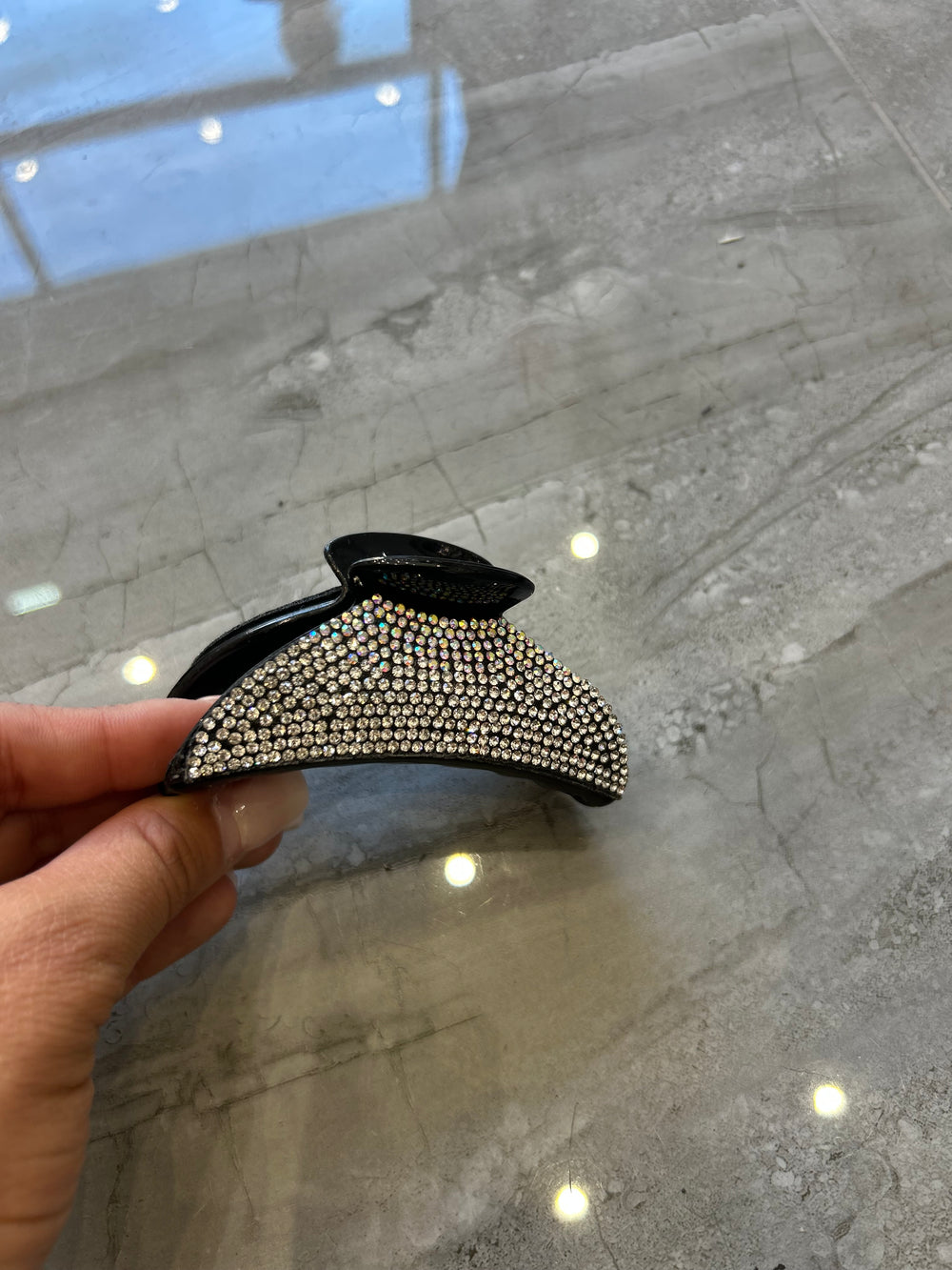A black hair clip detailed with silver crystal rhinestones 