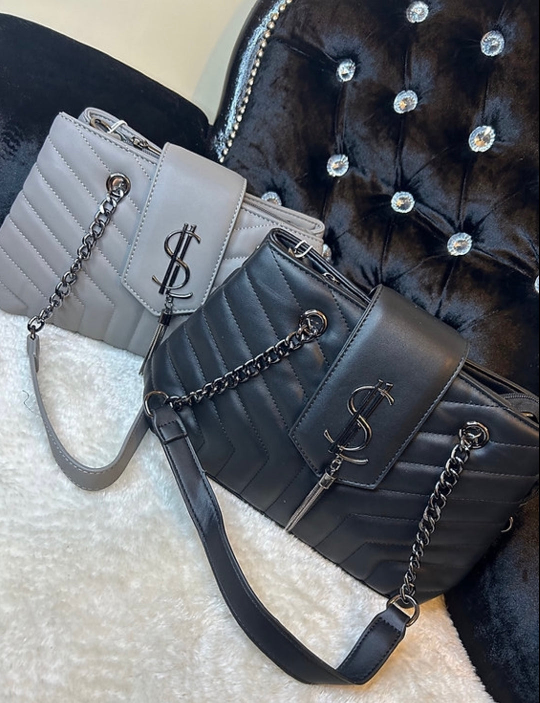 A collection of quilted medium sized handbags with chain detail in black and grey colours.
