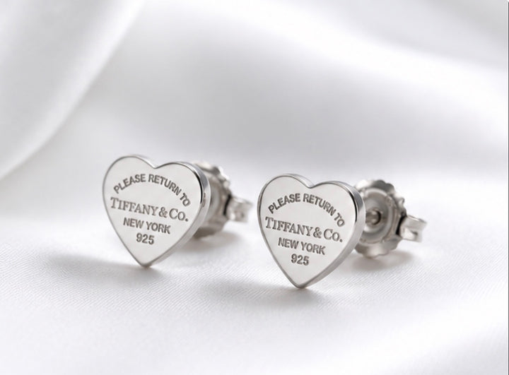 Silver heart-shaped stud earrings with engraved detail