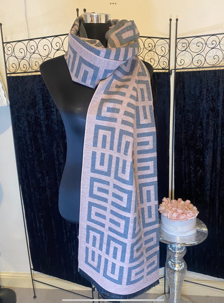 A geometric print scarf draped over a mannequin with a mix of geometric shapes in a monochrome colour palette.