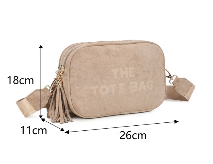 The Tote Bag beige double zip crossbody bag with tassel detail and adjustable strap.