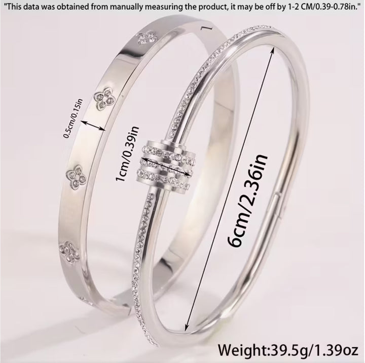 Two silver bracelets- one featuring screw-style detailing and the other with sparkling crystal embellishments and a wrap-around nail-inspired design.