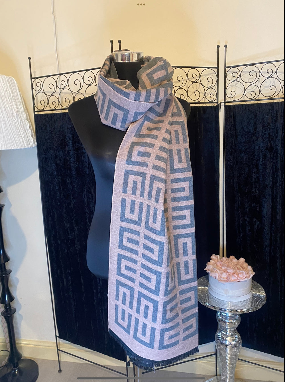 A geometric print scarf draped over a mannequin with a mix of geometric shapes in a monochrome colour palette.