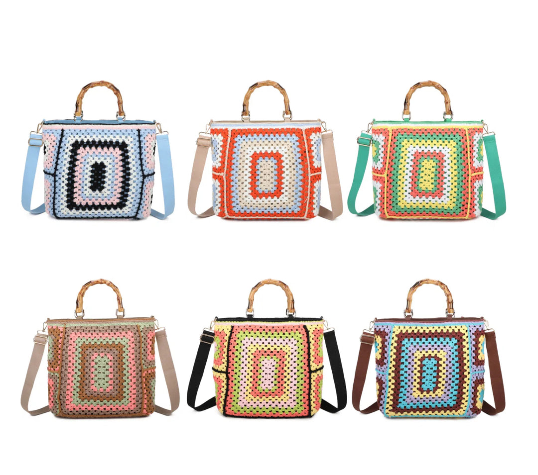A collection of colorful crochet grab bags with bamboo handles and a top zip closure. They feature a knitted crochet pattern all over, gold tone metal hardware, and different colored straps.