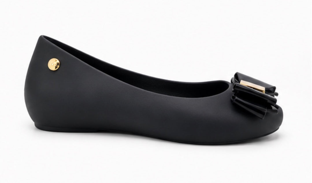 Women’s black jelly-style flats with decorative bow front