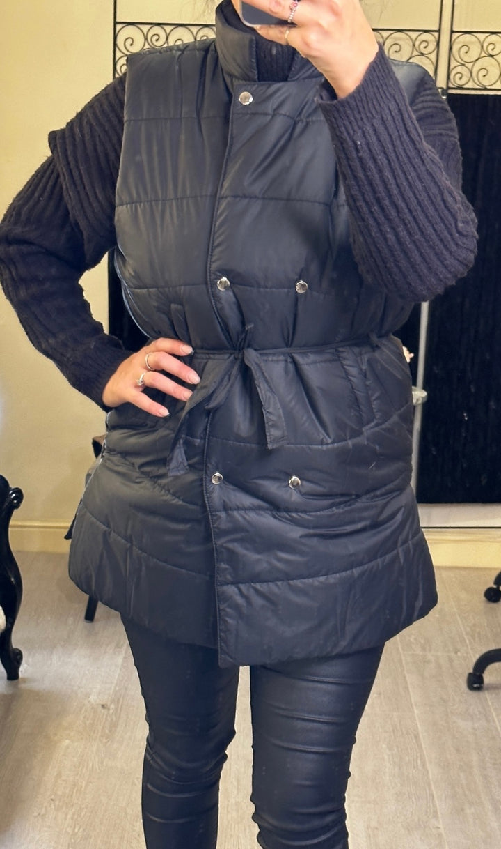  mid-length gilet, one in black with ribbon belt