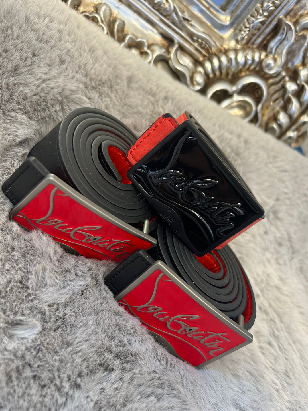Two belts with red and black colour scheme one with black buckle