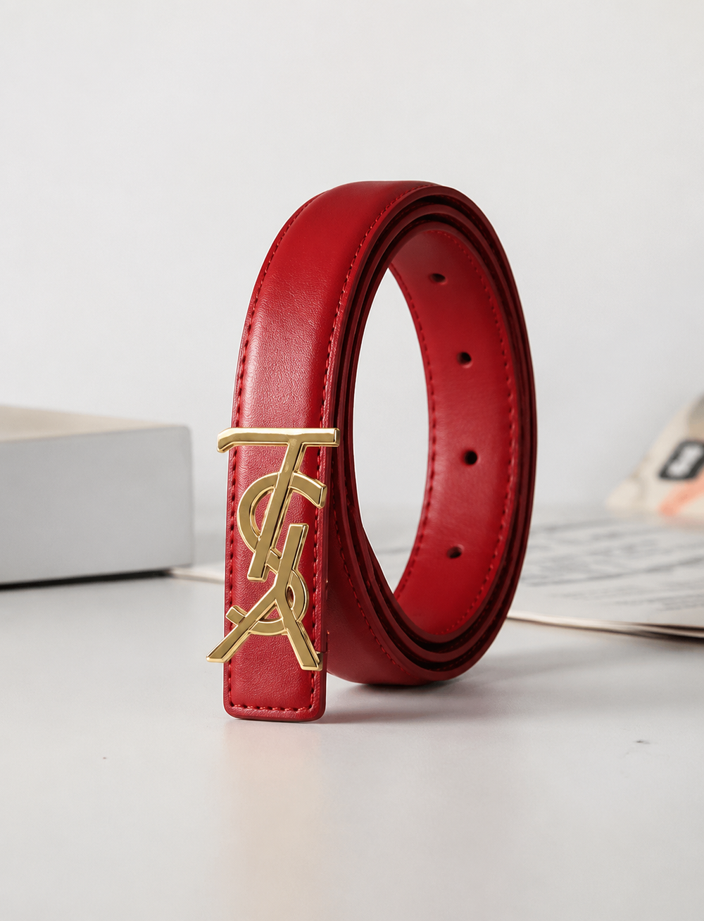 Burgundy slim faux leather belt with gold-tone statement buckle.