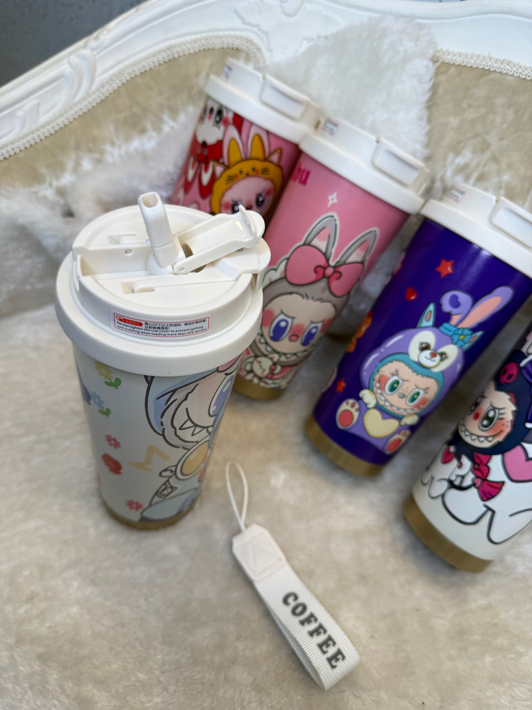 Colourful cartoon-themed coffee cups with a white lid