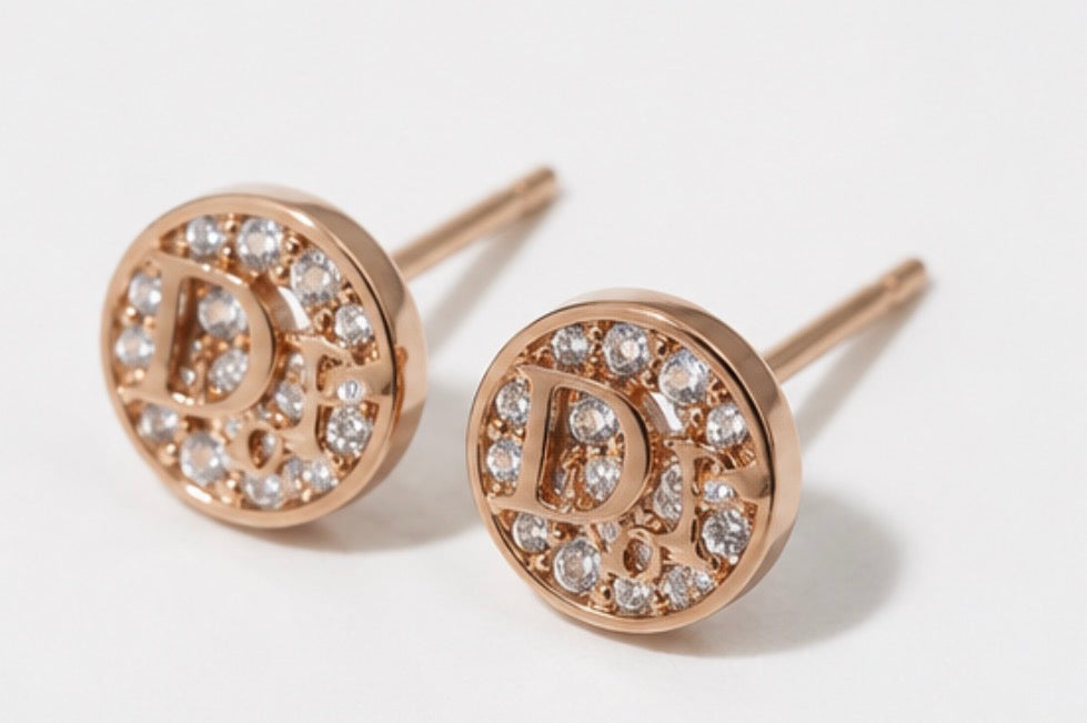 Rose gold crystal letter stud earrings displayed in a silver jewellery box