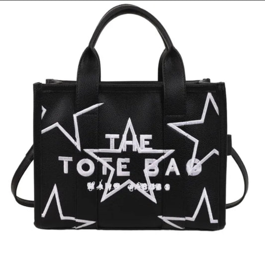 Black tote bag with white star designs and 'The Tote Bag' text on a white background