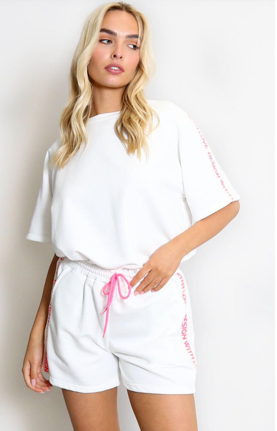a white shirt set co ord with pink writing  