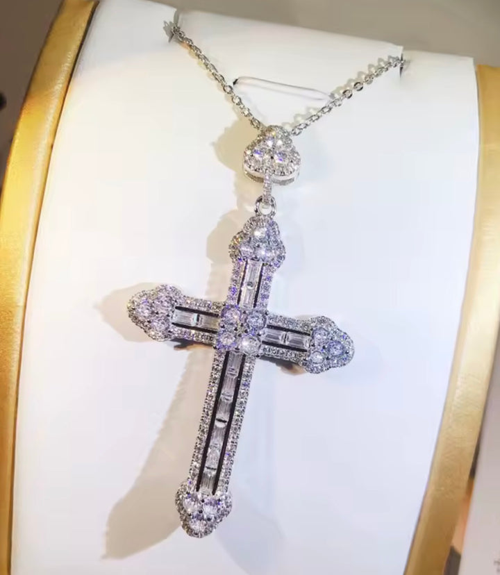 Diamond cross pendant on a white cushion with gold border