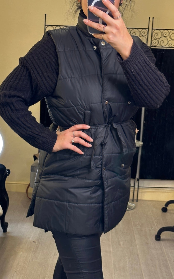  mid-length gilet, one in black with ribbon belt