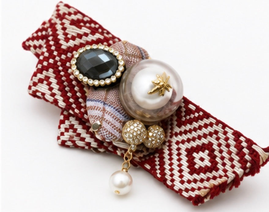 Red and black embellished fabric brooches featuring a crystal centre, faux pearl with gold bee detail and secure pin fastening