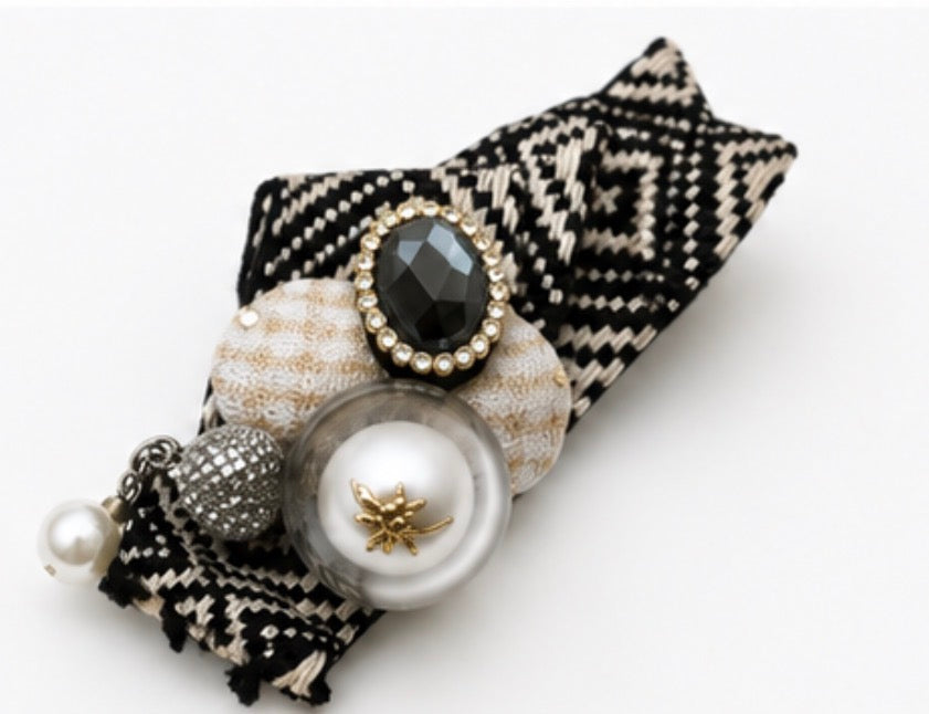 Red and black embellished fabric brooches featuring a crystal centre, faux pearl with gold bee detail and secure pin fastening