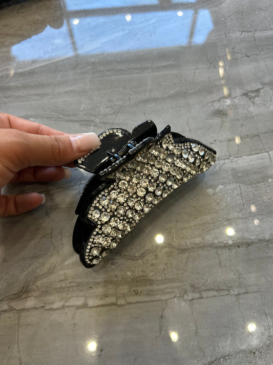 A large black hair clip detailed with silver crystal rhinestones and gems 
