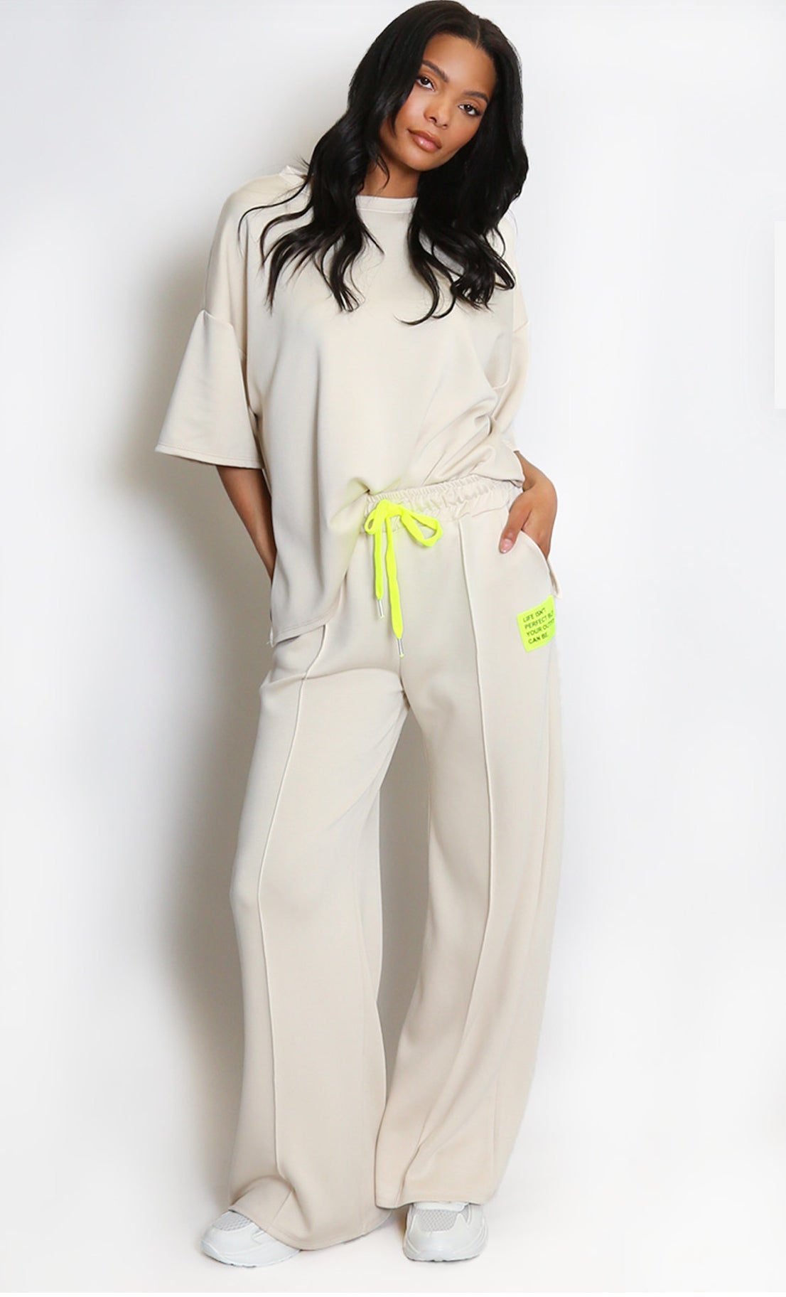 Woman wearing a beige outfit with neon accents