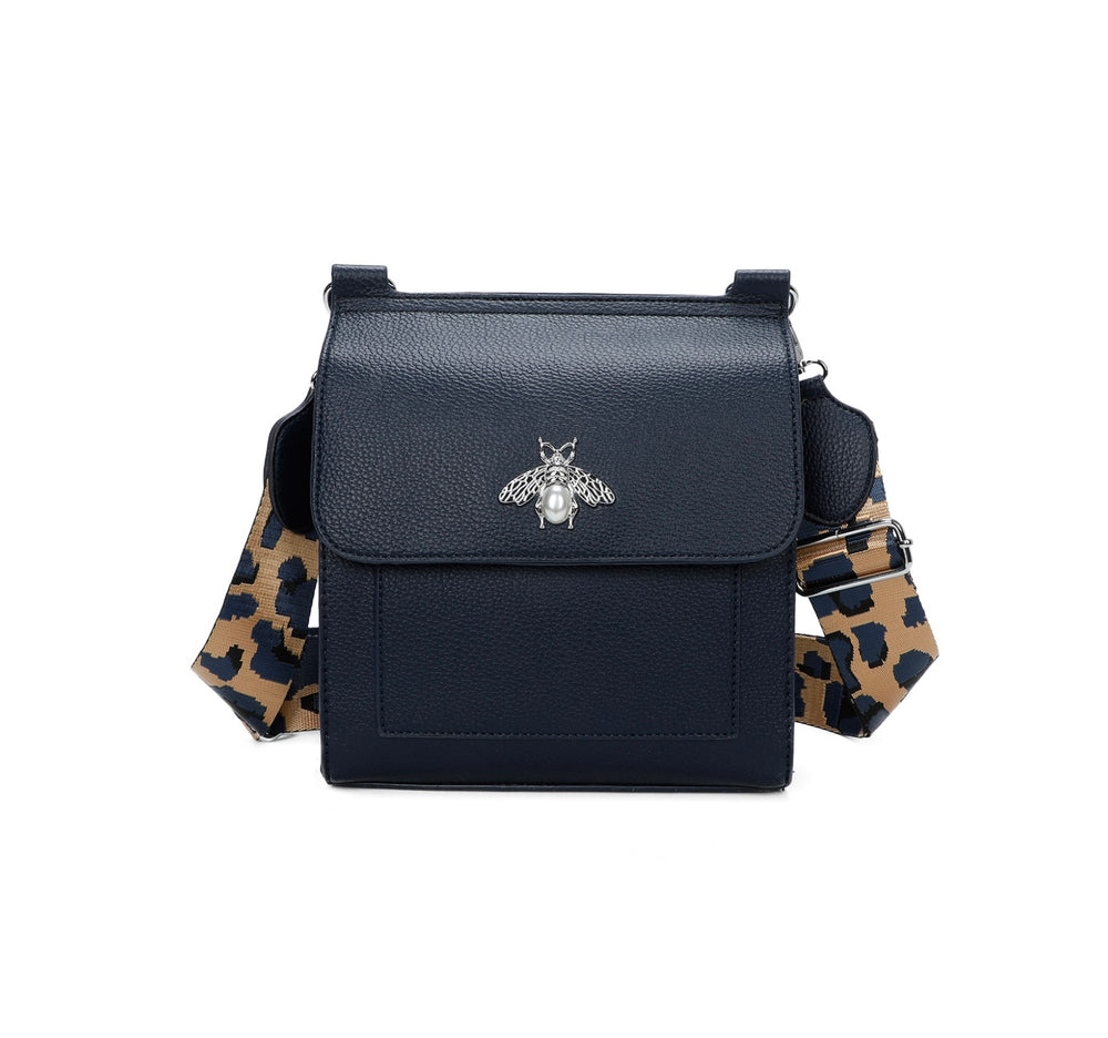 Navy crossbody bag with silver bee and pearl detail on flap, adjustable monochrome patterned straw