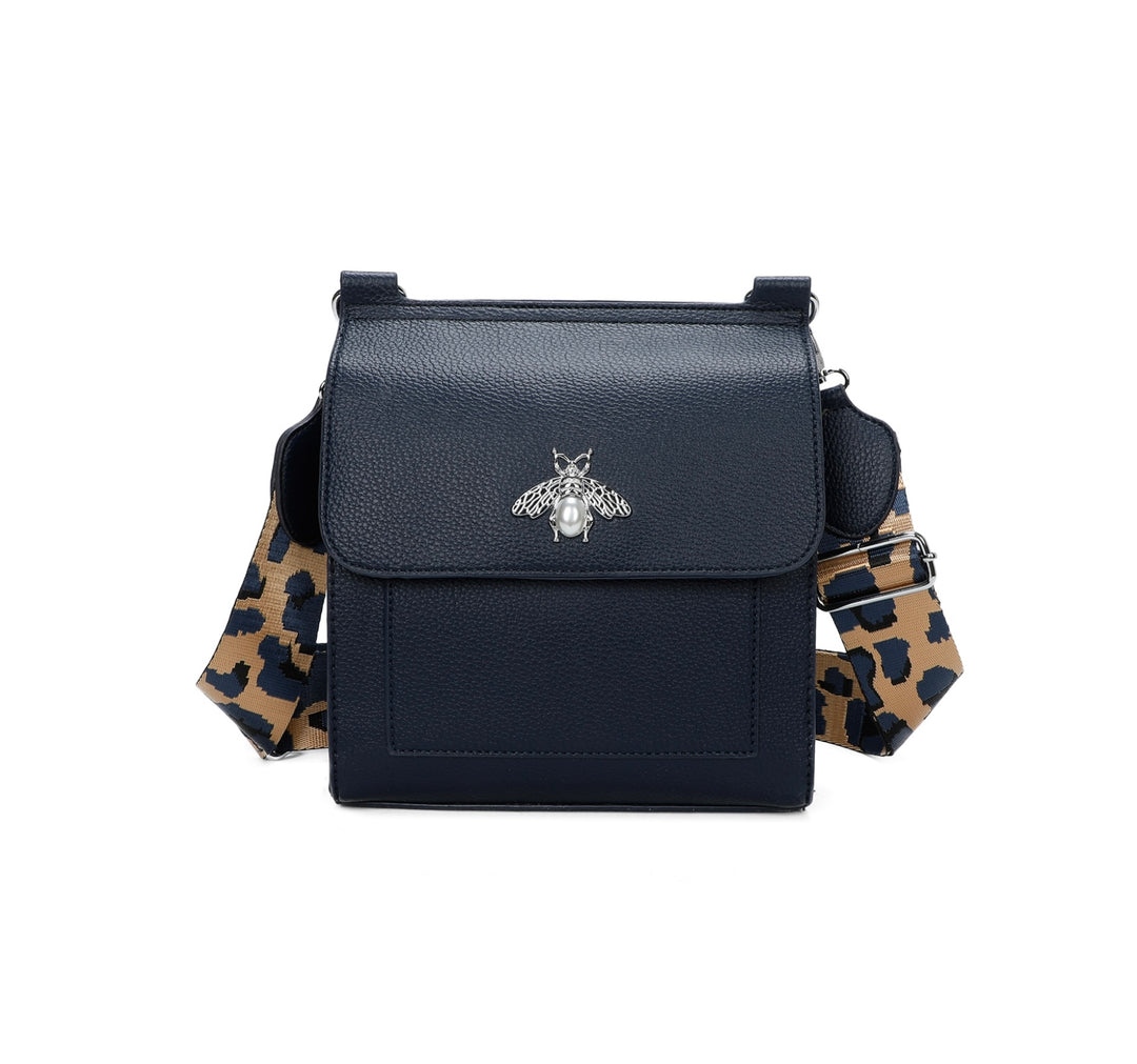 Navy crossbody bag with silver bee and pearl detail on flap, adjustable monochrome patterned straw