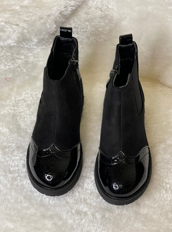 A pair of black ankle boots for girls with a glossy finish