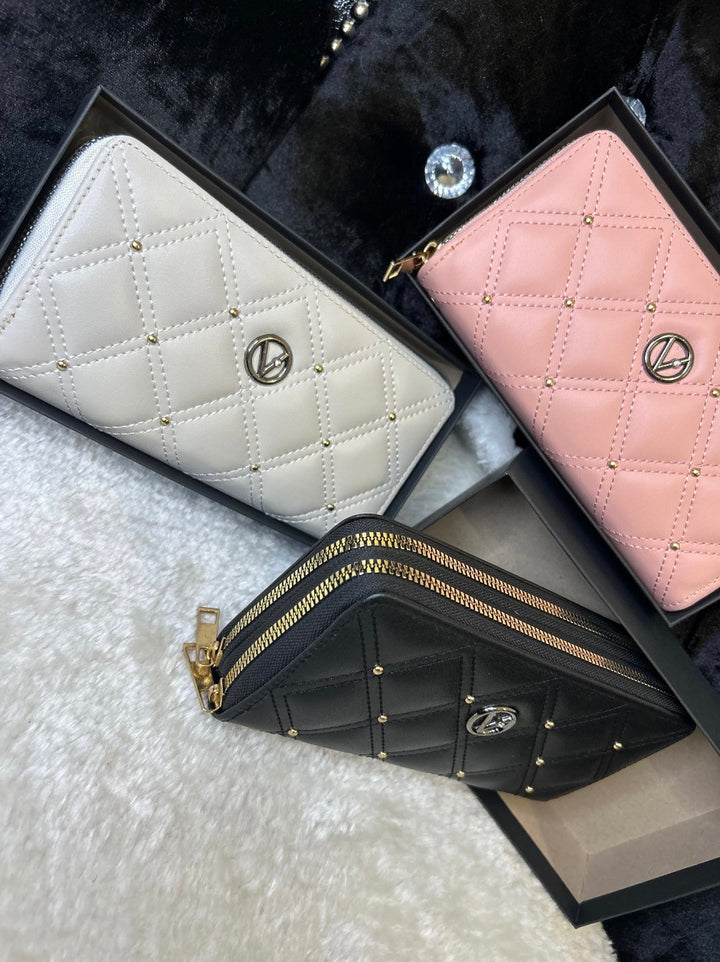 Three quilted leather purses in pink, white, and black, displayed side by side with zip compartments visible.