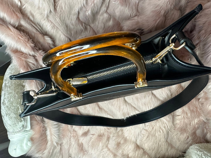 Birds Eye view  of black faux leather tote bag with the cbs logo on the front