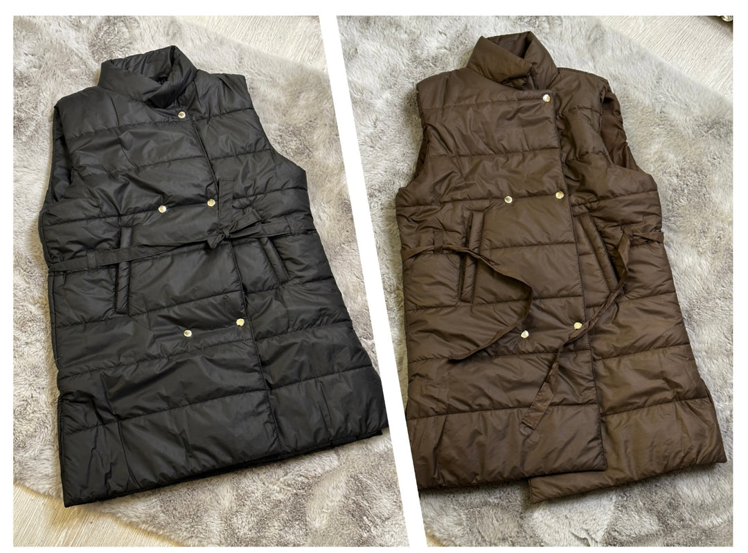 Two mid-length gillets, one in black and one in brown, laid out flat with ribbon belt