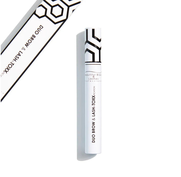 White cosmetic tube with black text stating duo brow &amp; lash toxx