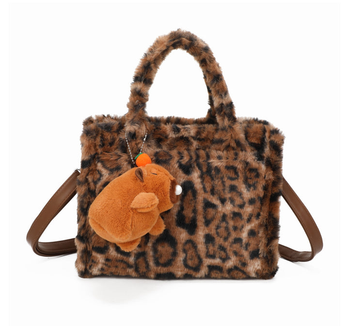 Leopard faux-fur tote bag with a small brown teddy bear keychain and matching handles and strap.