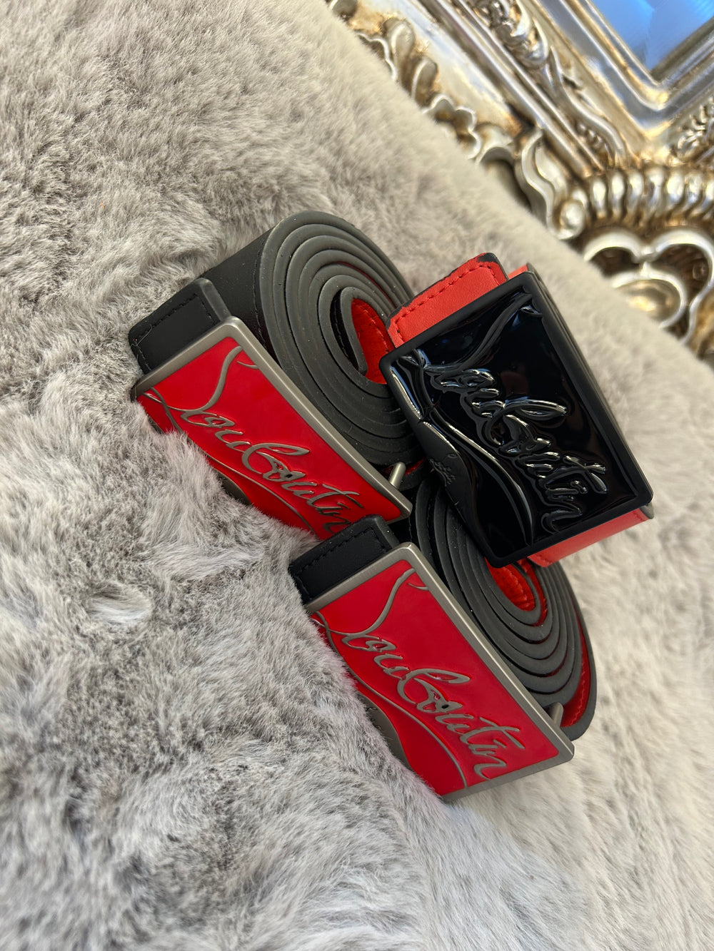 Two belts with red and black colour scheme one with black buckle