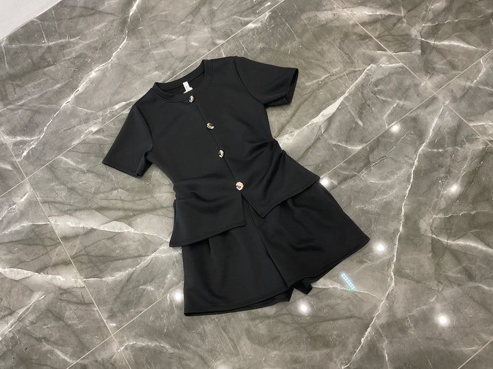 Black co ord set flat lay with gold button detail short sleeve top and shorts