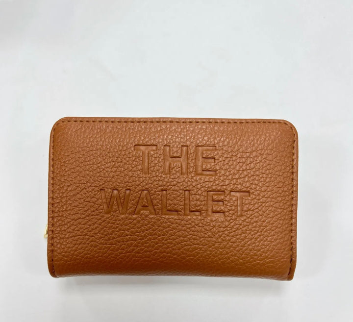 Tan purse with gold hardware and “the wallet” embossed on the front
