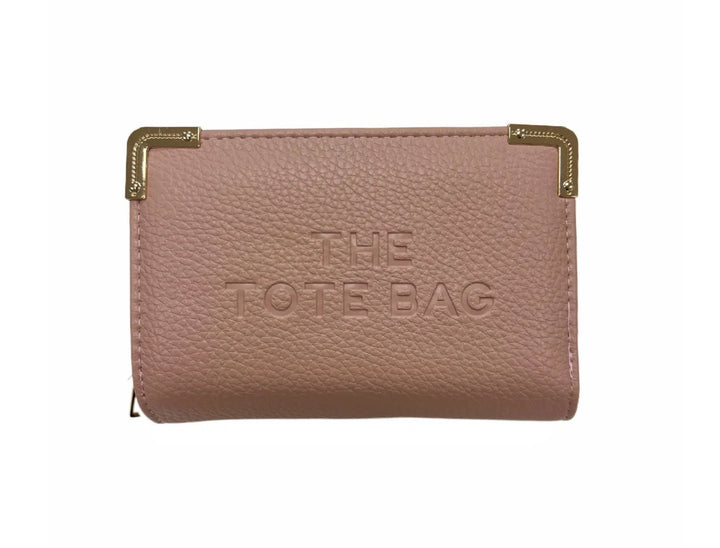 A pink synthetic tote bag with gold tone metal hardware, featuring a fold-over top with a closure, and the ‘THE TOTE BAG&