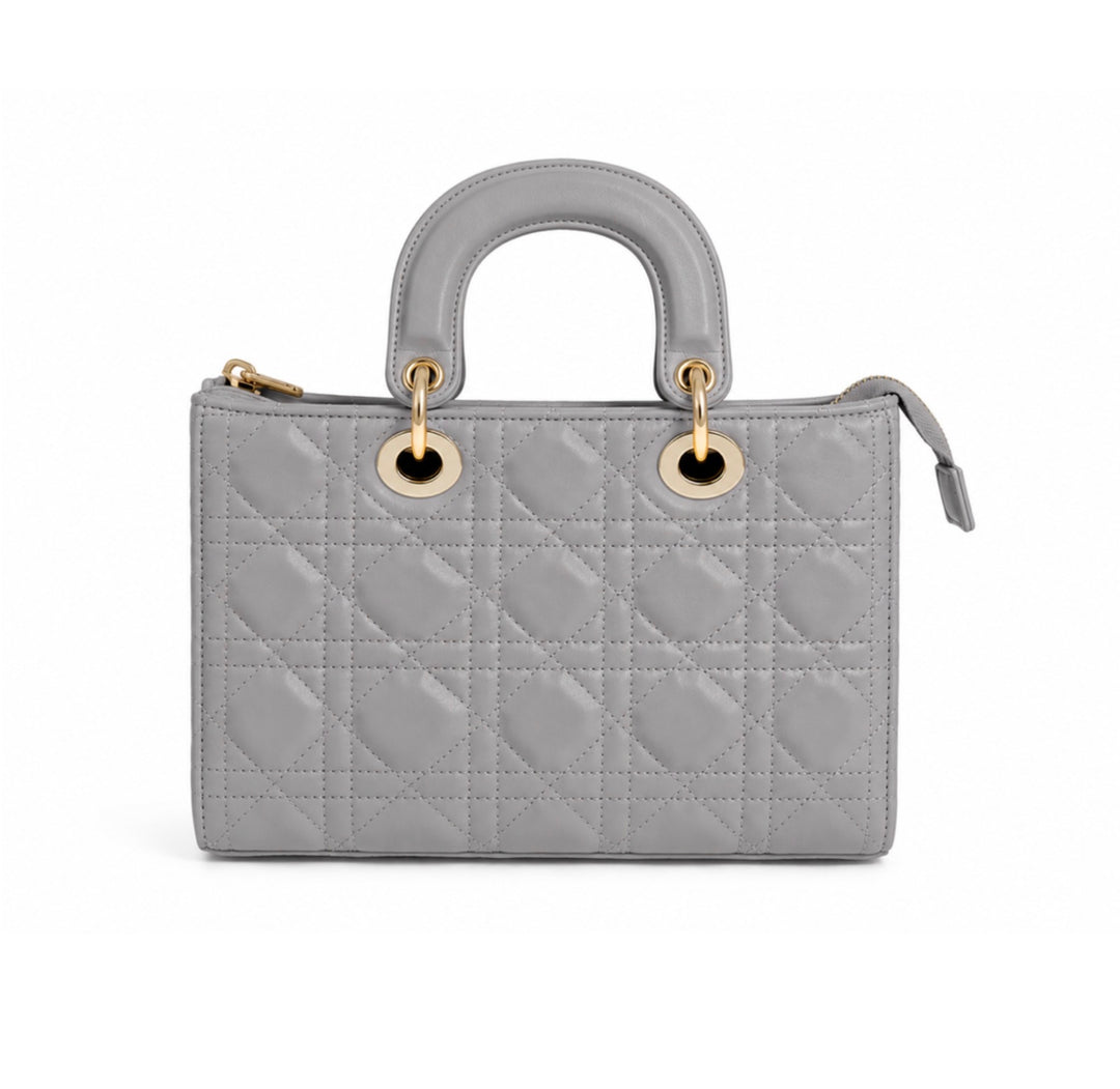 A light gray quilted leather top-handle handbag with gold-tone hardware, shown against a plain white background.