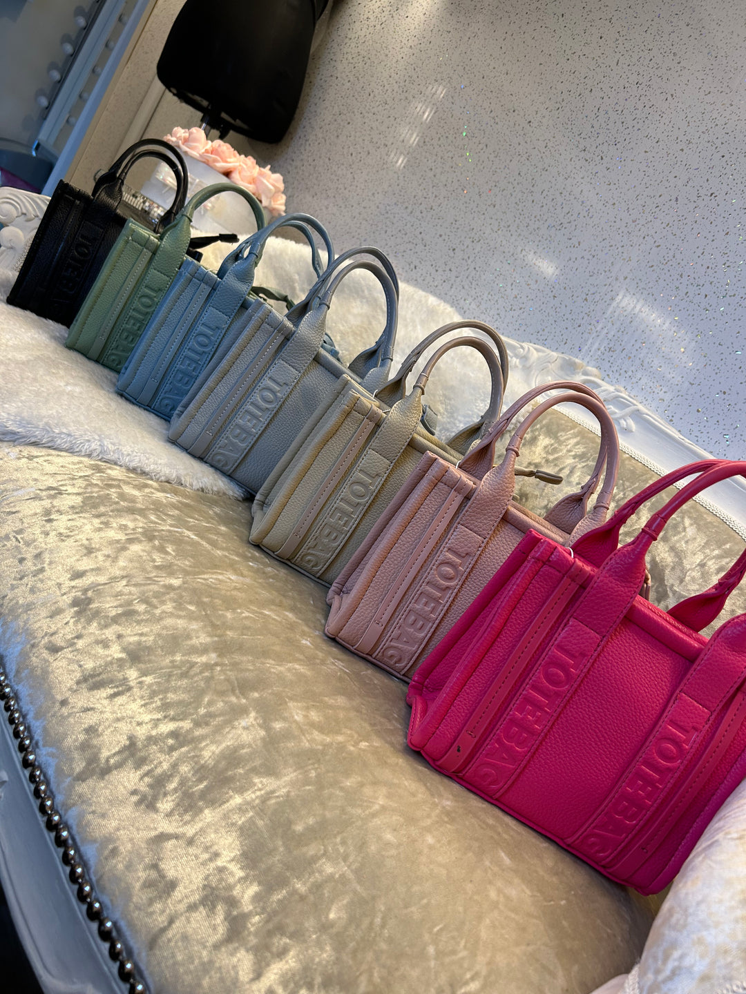 A collection of stripe dinky dot tote bags, with colours including green, blue, grey, and pink.